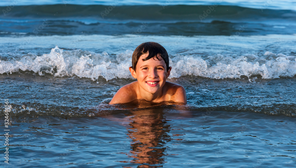 Child has fun and relaxes with the waves of the sea.