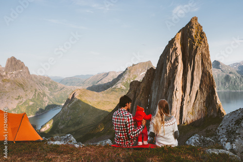 Family camping mother and father with baby travel vacations in mountains adventure healthy lifestyle parents with child in Norway enjoying Segla peak view sustainable tourism outdoor