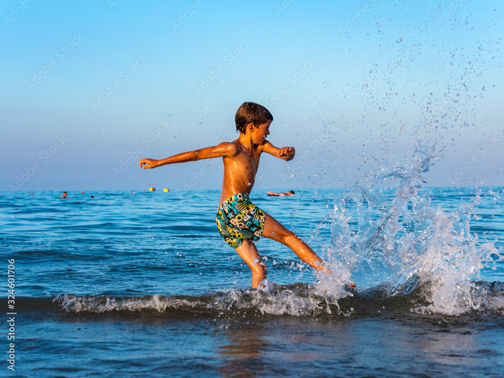 Child has fun and relaxes with the waves of the sea.