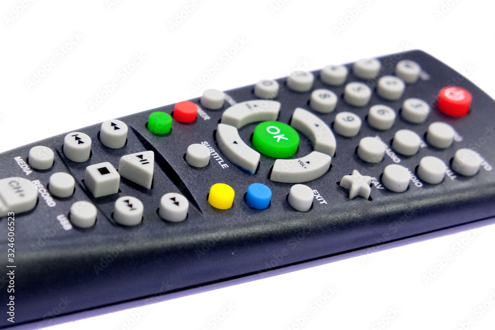 one black, dark gray TV remote control channel switch, green OK button, on a light, white background with backlight one black, dark gray TV remote control channel switch, green OK button, on a light, white background with backlight