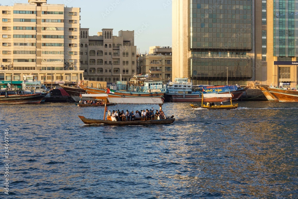 Dubai creek with traditional boats at sunset light