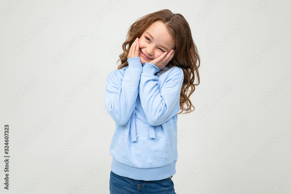 charming teen girl in a blue hoodie flirts on a white background charming teen girl in a blue hoodie flirts on a white background