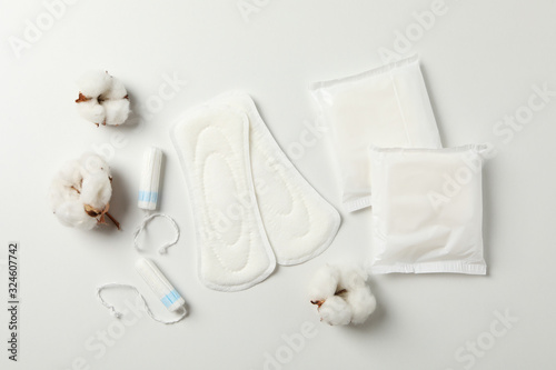 Sanitary pads, tampons and cotton on white background, top view