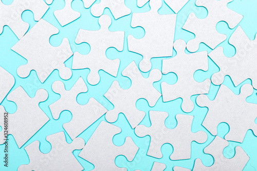 Pieces of a puzzle connected on a blue background with many other pieces of the puzzle. Business teamwork concept
