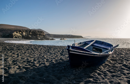 Small boat on black beach in Ajuy, Fuerteventura, Canary Islands