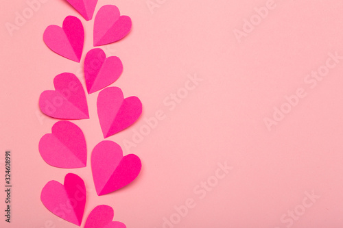 Love (Valentine's day) background or wedding background. Pink paper hearts on a pink pastel background. Love concept