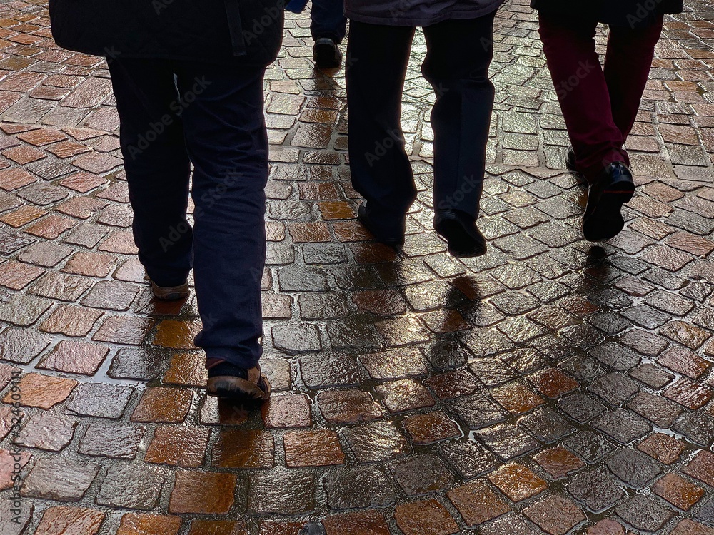 TRIER, GERMANY - OCTOBER 9, 2019: A group of men walk in the rainy weather TRIER, GERMANY - OCTOBER 9, 2019: A group of men walk in the rainy weather