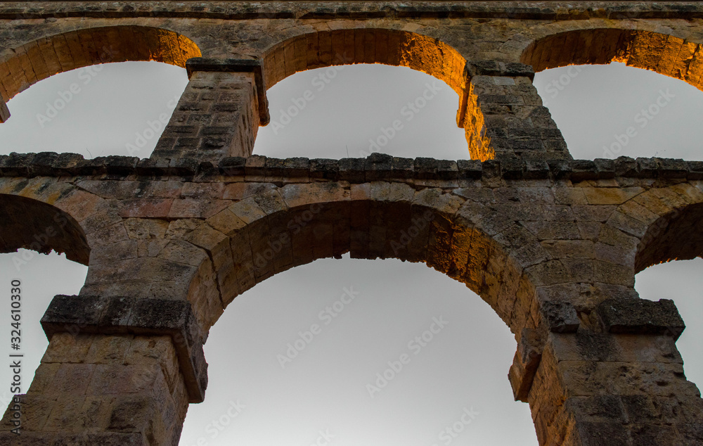 roman aqueduct tarragona.Roman aqueduct with arches at sunset.Close up of aqueduct