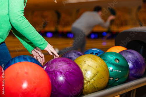 Child s hands reaching to pick up bowling ball at Bowling alley