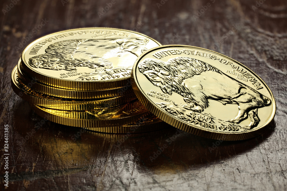 1 ounce American Buffalo gold bullion coins on wooden background 1 ounce American Buffalo gold bullion coins on wooden background