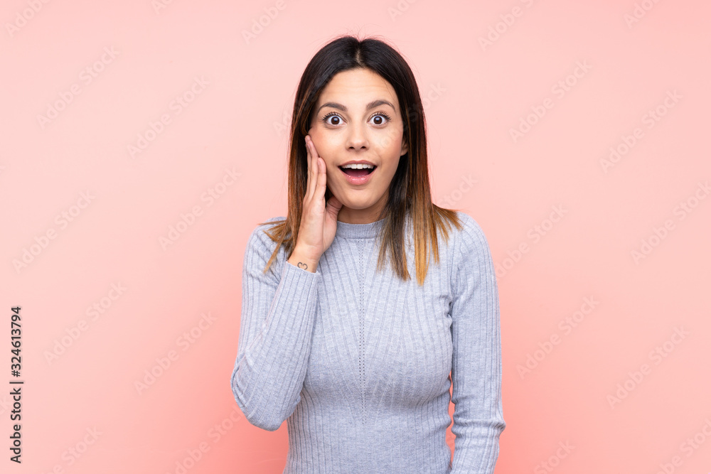 Fototapeta premium Woman over isolated pink background with surprise and shocked facial expression
