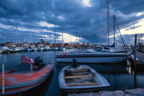 Boats in motion blur effect in Alghero harbor at night