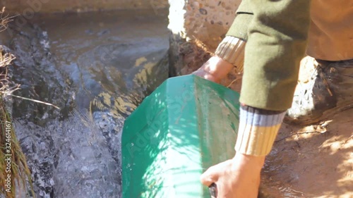 Local people of Ain Chouatar filling jerrycan with water. Morocco  photo