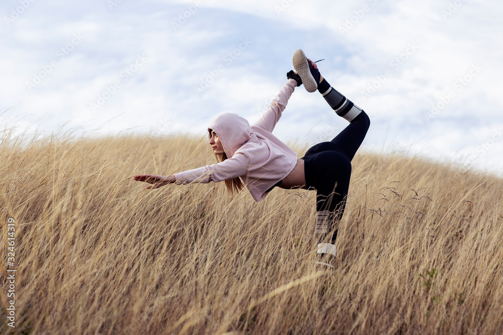 Young woman exercise in dry grass after joggin in the nature Young woman exercise in dry grass after joggin in the nature