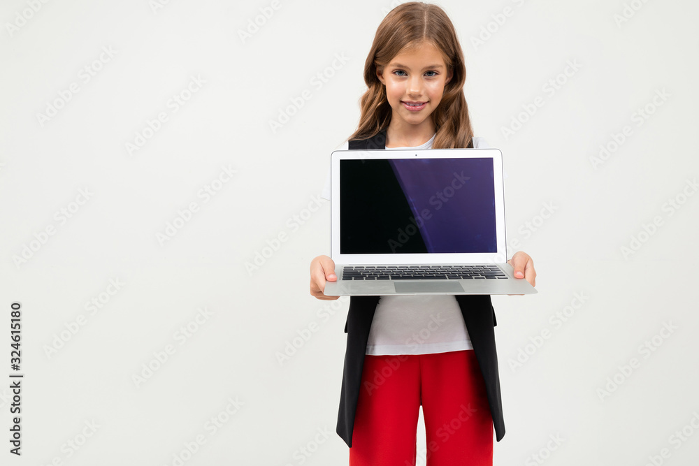 Pretty girl in black and red costume shows a laptop isolated on white background