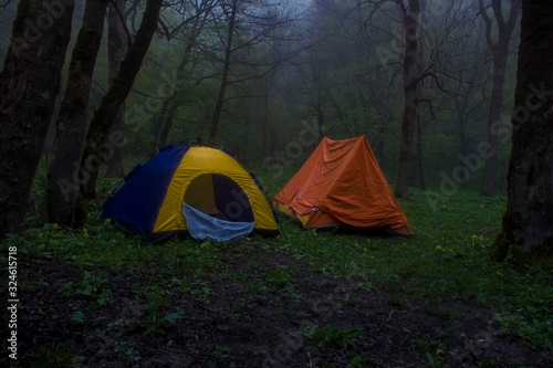 tent in the foggy night forest