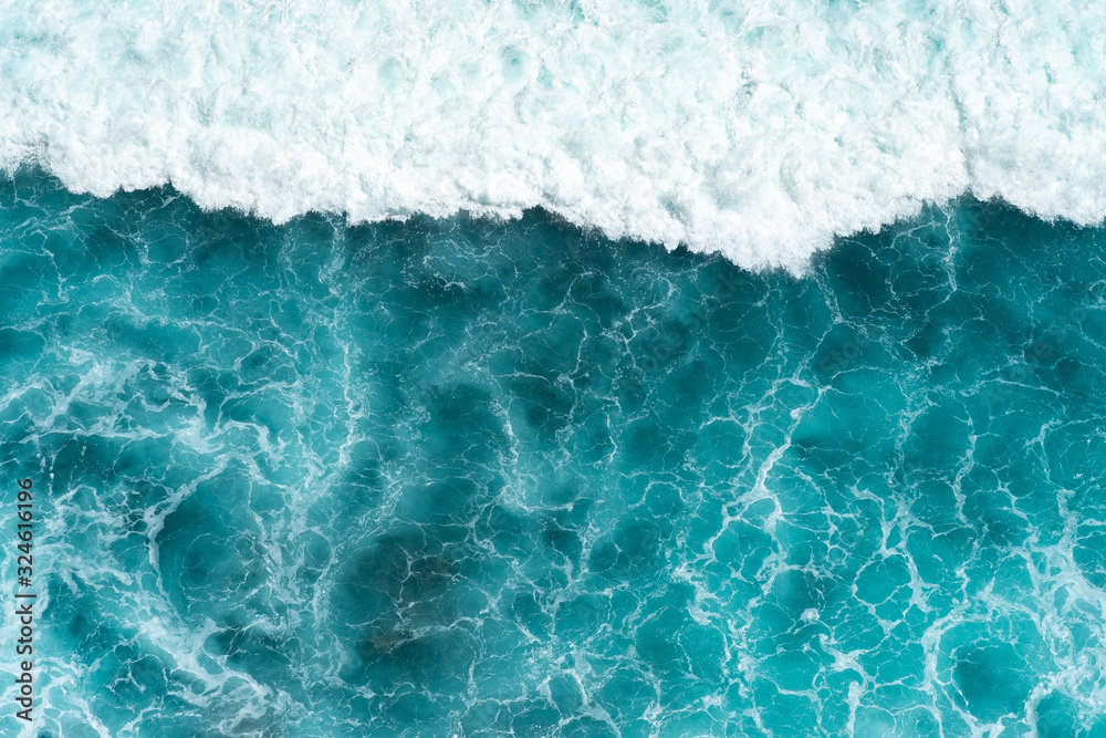 Fototapeta premium Texture Light blue surface of raging sea water with white foam and wave pattern