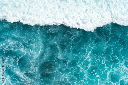 Texture Light blue surface of raging sea water with white foam and wave pattern
