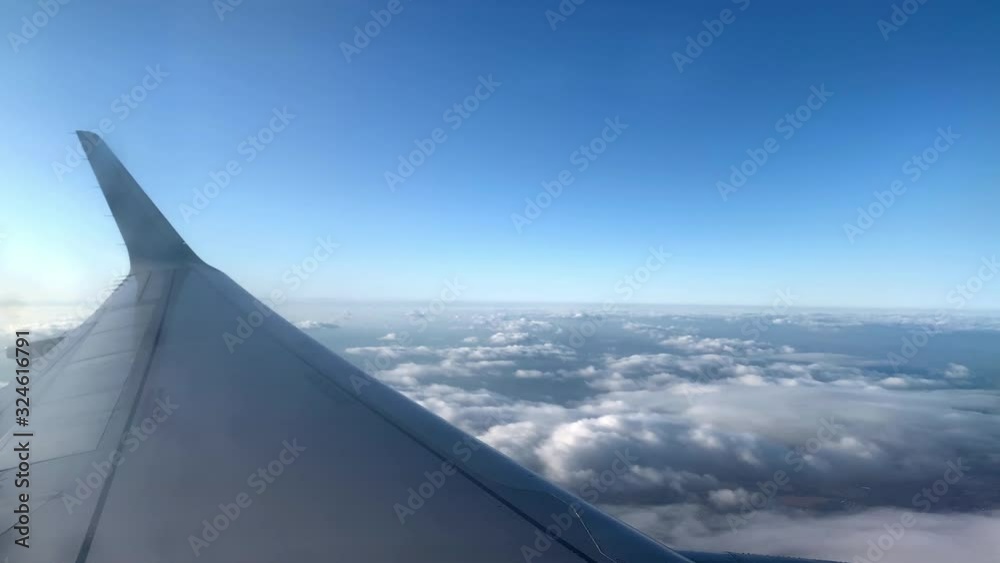airplane wing high above clouds cruising in sky airplane wing high above clouds cruising in sky