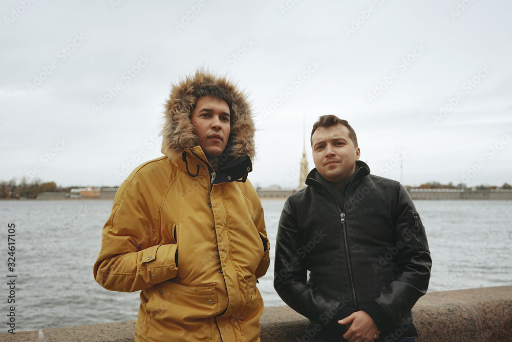 Two men standing on the river Bank. Neva river in autumn. Tourism in Saint-Petersburg
