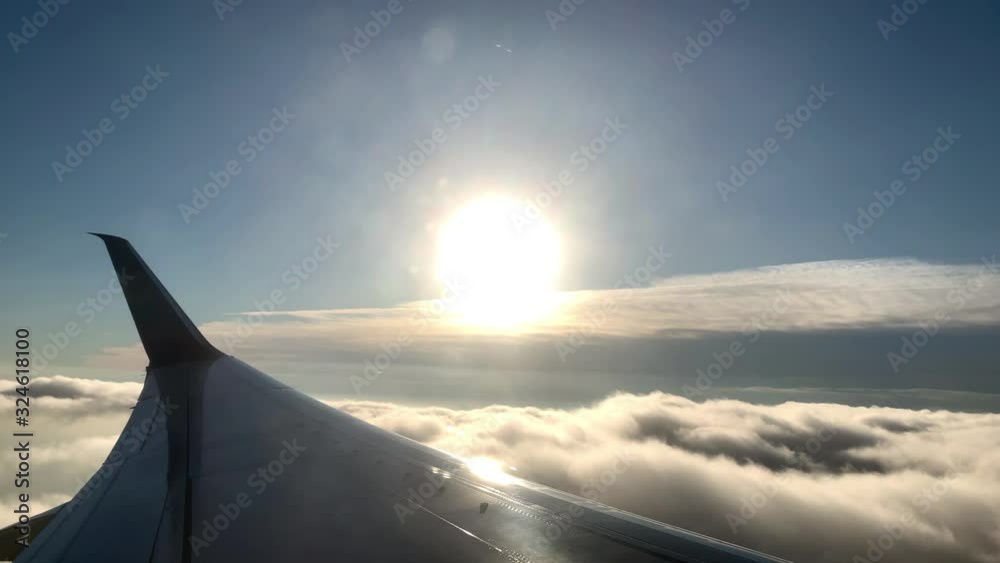 bright sun over clouds in sky airplane wing view bright sun over clouds in sky airplane wing view