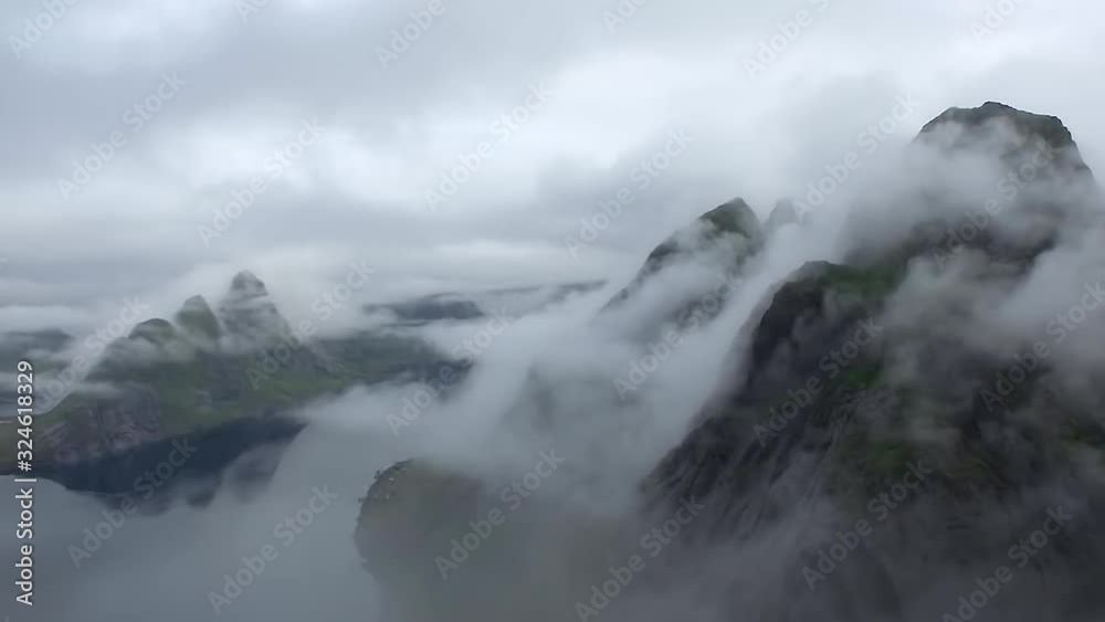 Norway mountain on sunset clouds. Top point of view. Aerial view from drone in clouds. Helicopter shot amazing beautiful view of the cliffs Norway mountain on sunset clouds. Top point of view. Aerial view from drone in clouds. Helicopter shot amazing beautiful view of the cliffs