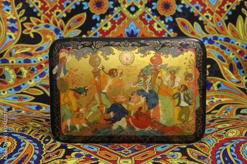 Palekh painting. Casket with traditional national Russian lacquer miniature on papier-mache. Ornamental Pavlovo Posad shawl. Russian style in folk art, handicraft photo