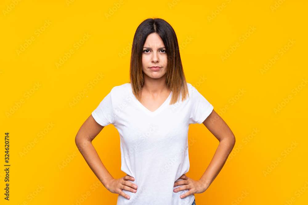 Obraz premium Young woman over isolated yellow background angry