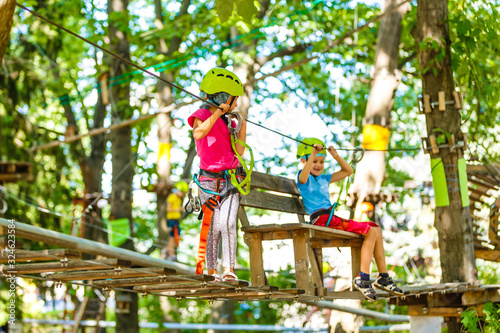 happy little children in a rope park on the wood background