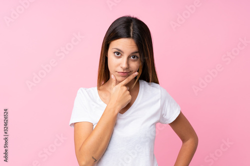 Young woman over isolated pink background thinking