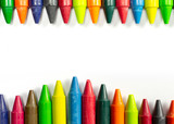 Colourful bright wax pencils on the top and bottom isolated on white and free space in the centre of composition.