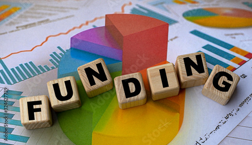 The concept of the word funding on cubes against the background of the graph