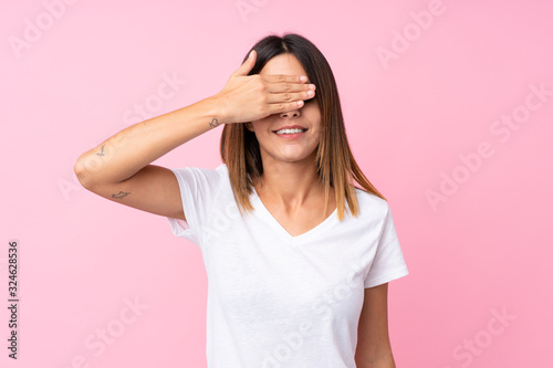 Young woman over isolated pink background covering eyes by hands. Do not want to see something