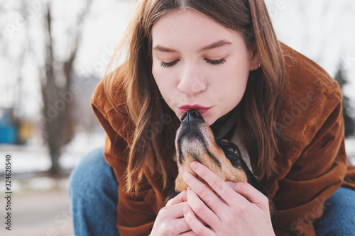 Εκτύπωση καμβά Loving and adoring pets concept: Young woman kisses her little dog