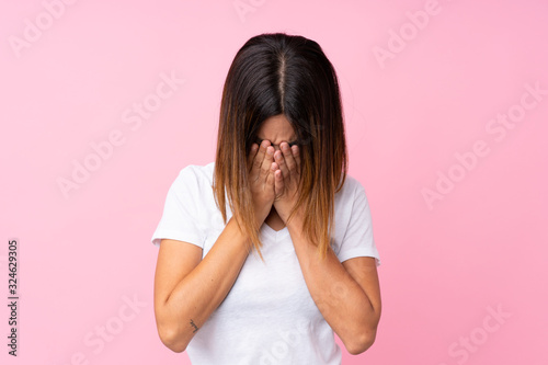 Young woman over isolated pink background with tired and sick expression
