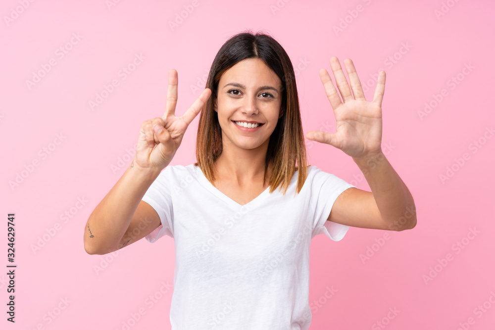 Young woman over isolated pink background counting seven with fingers