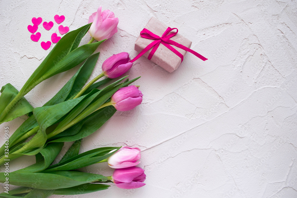 Beautiful spring tulips with hearts and gift box on grey stone background. Concept of Valentines day, Women's Day March eight, Mothers day. Space for text, flat lay.