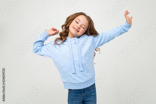 sleepy teenager girl in casual blue hoody yawns on a white background