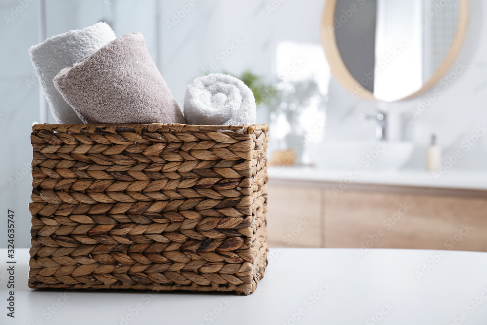 Fototapeta premium Wicker basket with clean soft towels in bathroom. Space for text