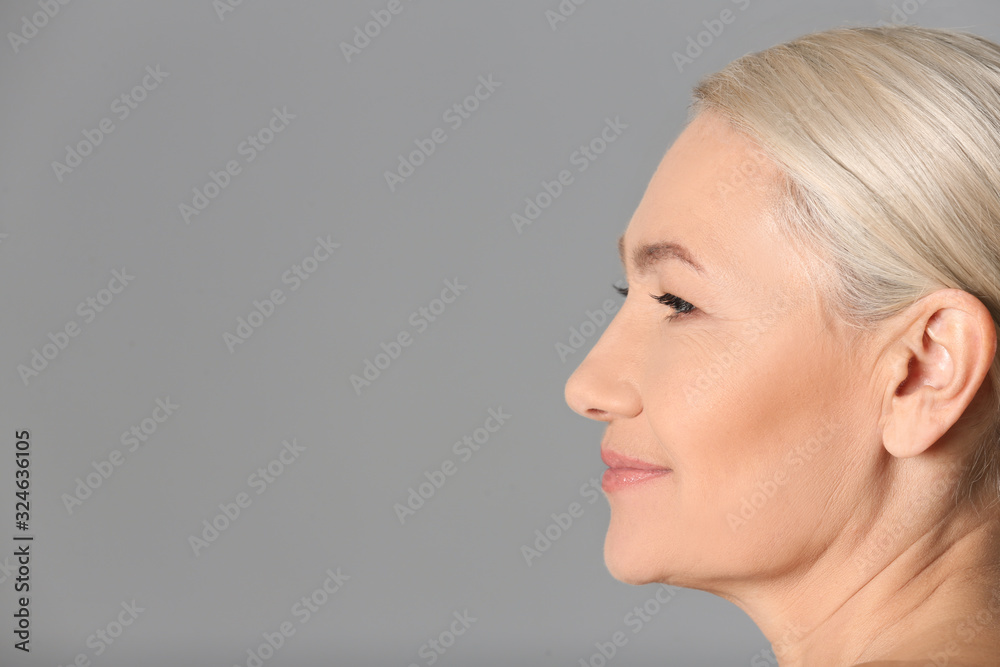 Portrait of beautiful mature woman on grey background, closeup. Space for text