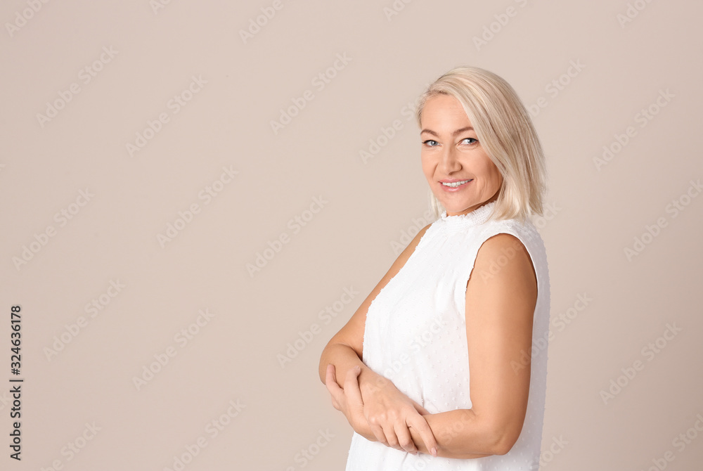 Naklejka premium Portrait of beautiful mature woman on beige background. Space for text