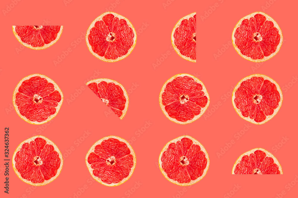 Grapefruit tropical pattern texture, creative flat lay, fruit slices on pink background Grapefruit tropical pattern texture, creative flat lay, fruit slices on pink background