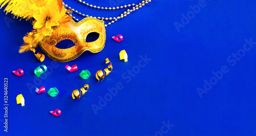 Carnival mask on blue background with silver beads. Mardi Gras concept. Copy space