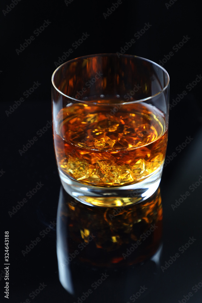 glass of whiskey with ice on black background glass of whiskey with ice on black background