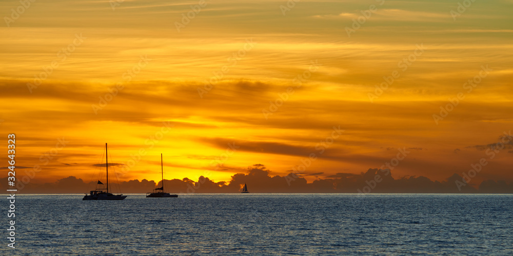 Seascape panoramic view at sunset. Boats and yachts in the foreground. Hawaii, Maui island.