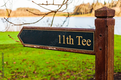 11th Tee sign golf club course in Ireland. Hole number on wooden sign.