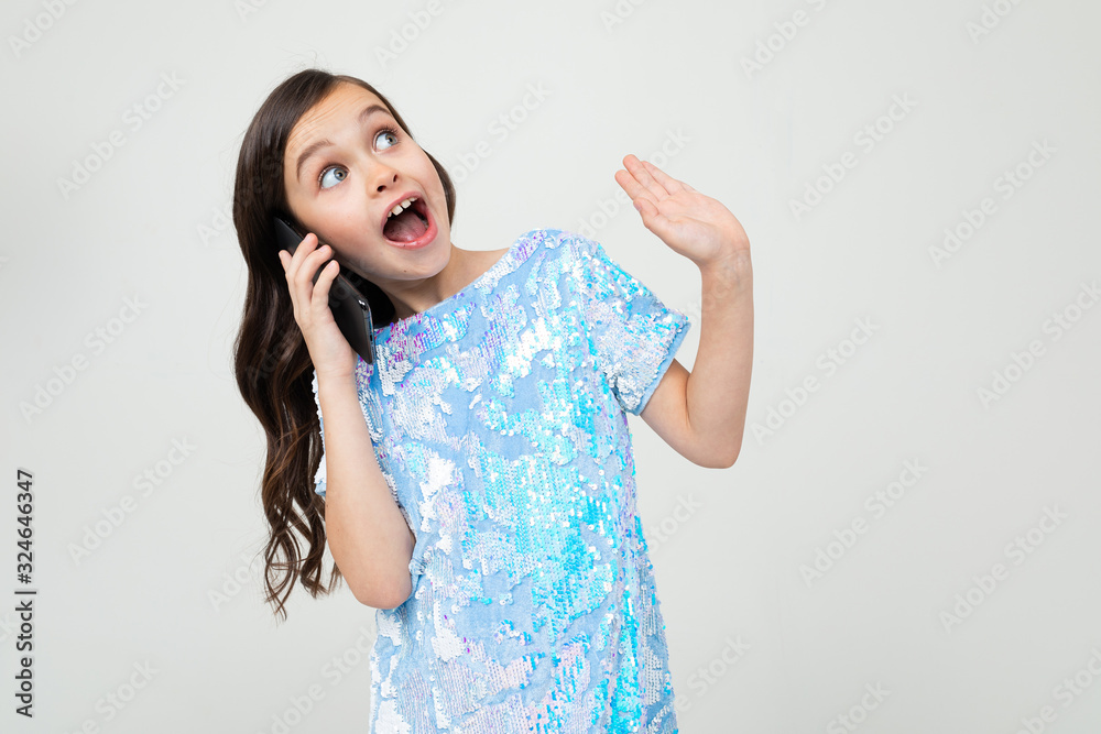 girl emotionally communicates on the phone on a white studio background girl emotionally communicates on the phone on a white studio background