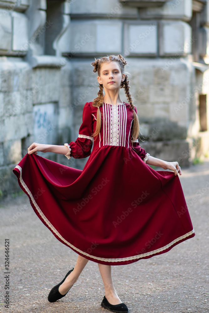 Young girl with two pigtails, portrait of a girl with pigtails, a girl in a red dress on a walk Young girl with two pigtails, portrait of a girl with pigtails, a girl in a red dress on a walk