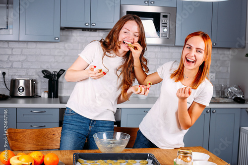 Girl friends couple cooking in the kitchen together