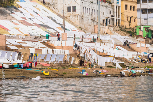 Colorful sheets and blankets near a ghat, waiting to get dried in the sunlight near the Ganges river. Indian lifestyle. Varanasi, India.